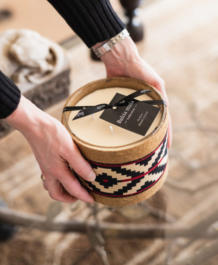 hands putting an interior candle on a glass table