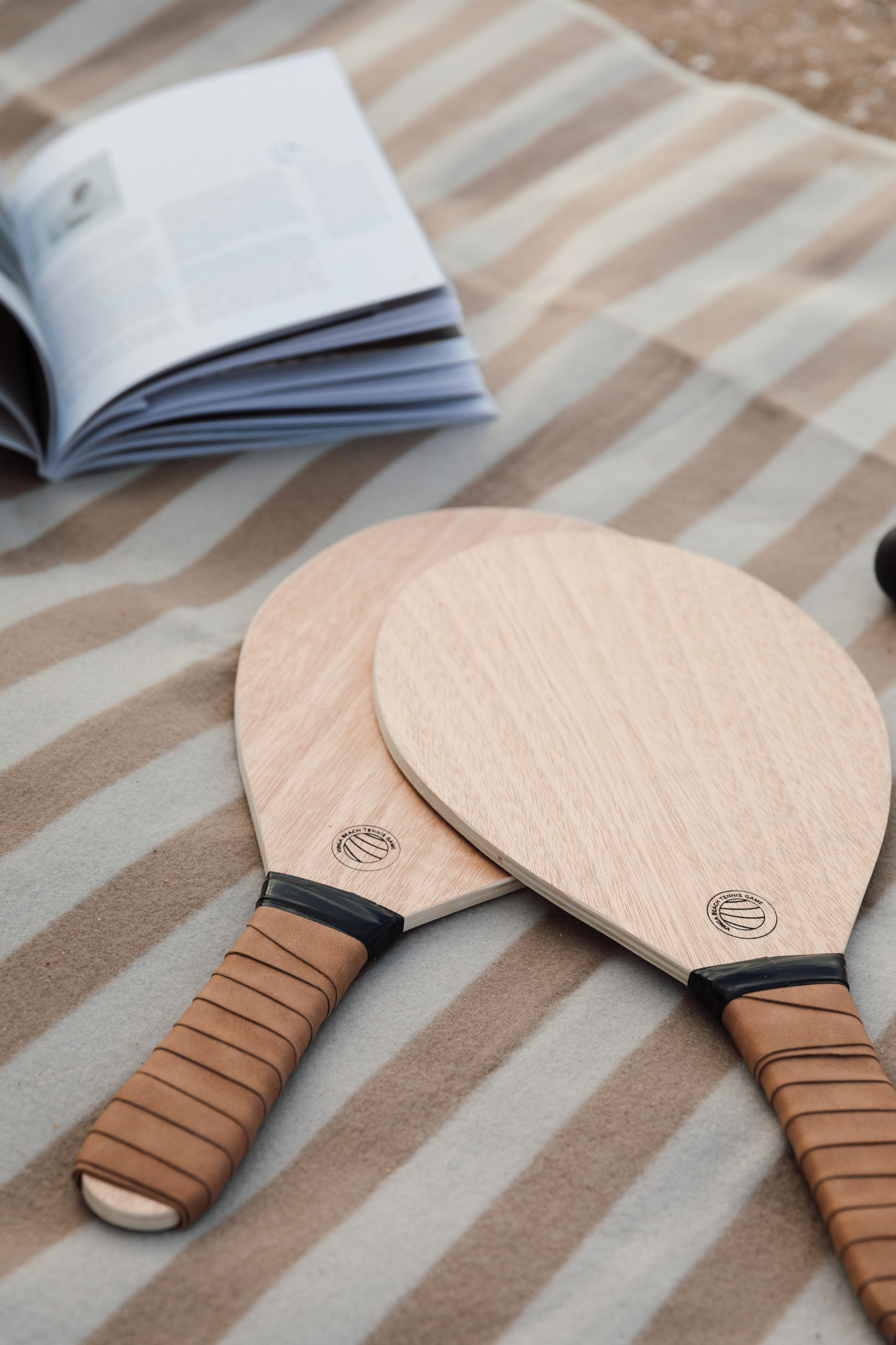 two beach rackets on a beach towel