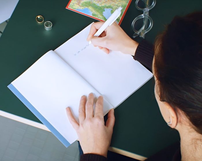 woman writing on a notebook with a Prodir pen